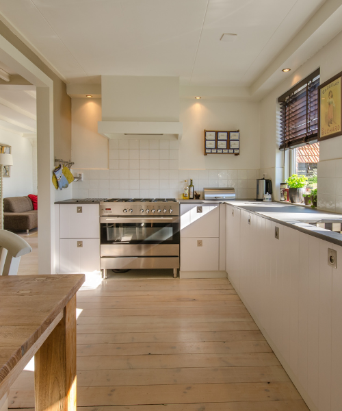 A kitchen with a wooden floor and white cabinets